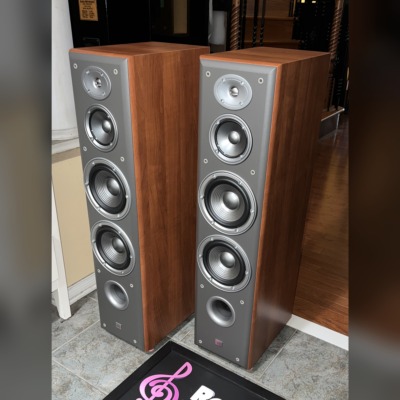 Angled view of the JBL Northridge E80 towers, grilles off, showing the cherry side panels and grey front baffles