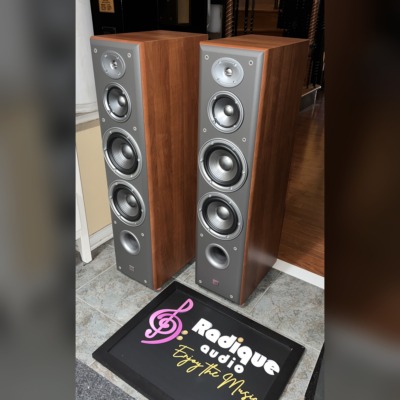 Angled view of the JBL Northridge E80 towers, grilles off, showing the cherry side panels and grey front baffles