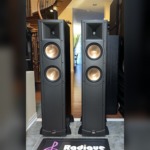 Pair of Klipsch RF-62 floorstanding speakers square on with grilles off, horn-loaded tweeter above two copper-spun woofers on each black tower
