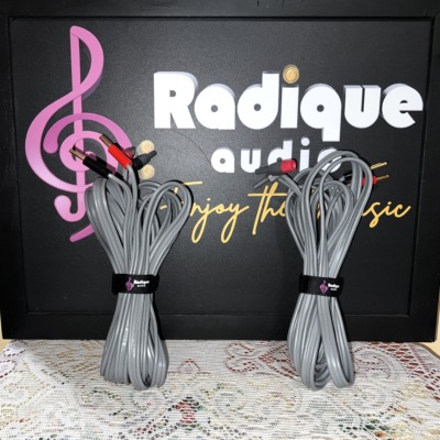 Linn K20 speaker cables, a coiled pair in grey jacket with red and black banana plugs, each held by a Radique Audio cable tie