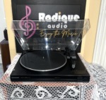 Marantz TT151 automatic turntable head-on with the lid lifted, black platter mat with silver rim, tonearm and Marantz-badged front lip
