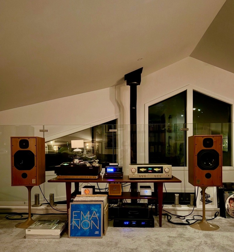 Michael F.’s listening loft at night: Harbeth monitors on tulip stands either side of an Accuphase integrated amplifier and a turntable on a wood console