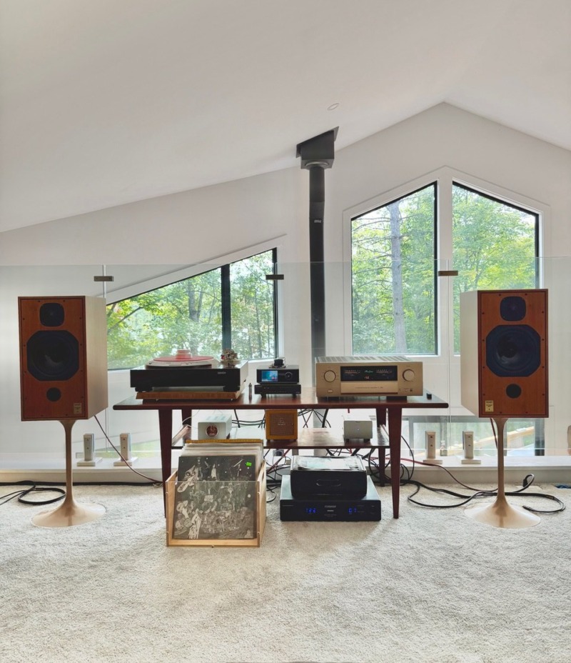 Michael F.’s listening loft by day: Harbeth monitors, an Accuphase integrated amplifier and a turntable in front of tall windows onto the trees