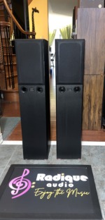 Pair of Monitor Audio Bronze 3 tower speakers in black ash with cloth grilles over the drivers and the twin front ports left uncovered