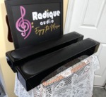Two Monitor Audio Radius 250HD speakers with their black cloth grilles fitted, angled view of the gloss black cabinets