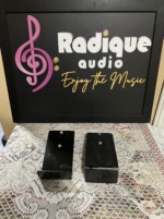 Wall side of the Monitor Audio Radius 90 brackets, two black steel wall plates with their screw holes, shown flat on a lace table