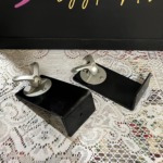 Monitor Audio Radius 90 wall brackets, a pair of black L-shaped arms each topped with a silver swivel ball joint and speaker mounting plate