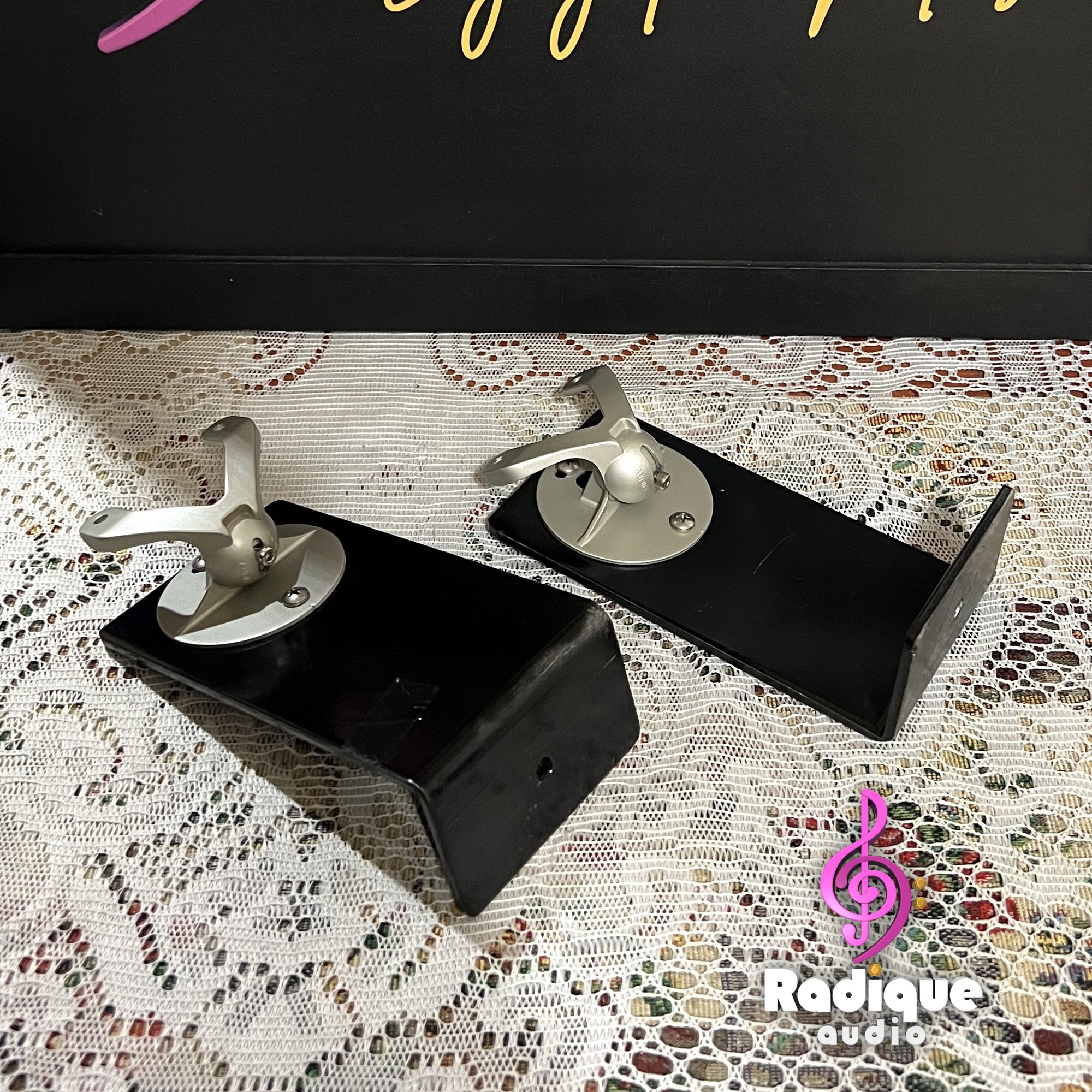Monitor-Audio-Radius-90-Wall-Brackets-Pair-Front-Angle-Thumb-Logo Monitor Audio Radius 90 wall brackets, a pair of black L-shaped arms each topped with a silver swivel ball joint and speaker mounting plate