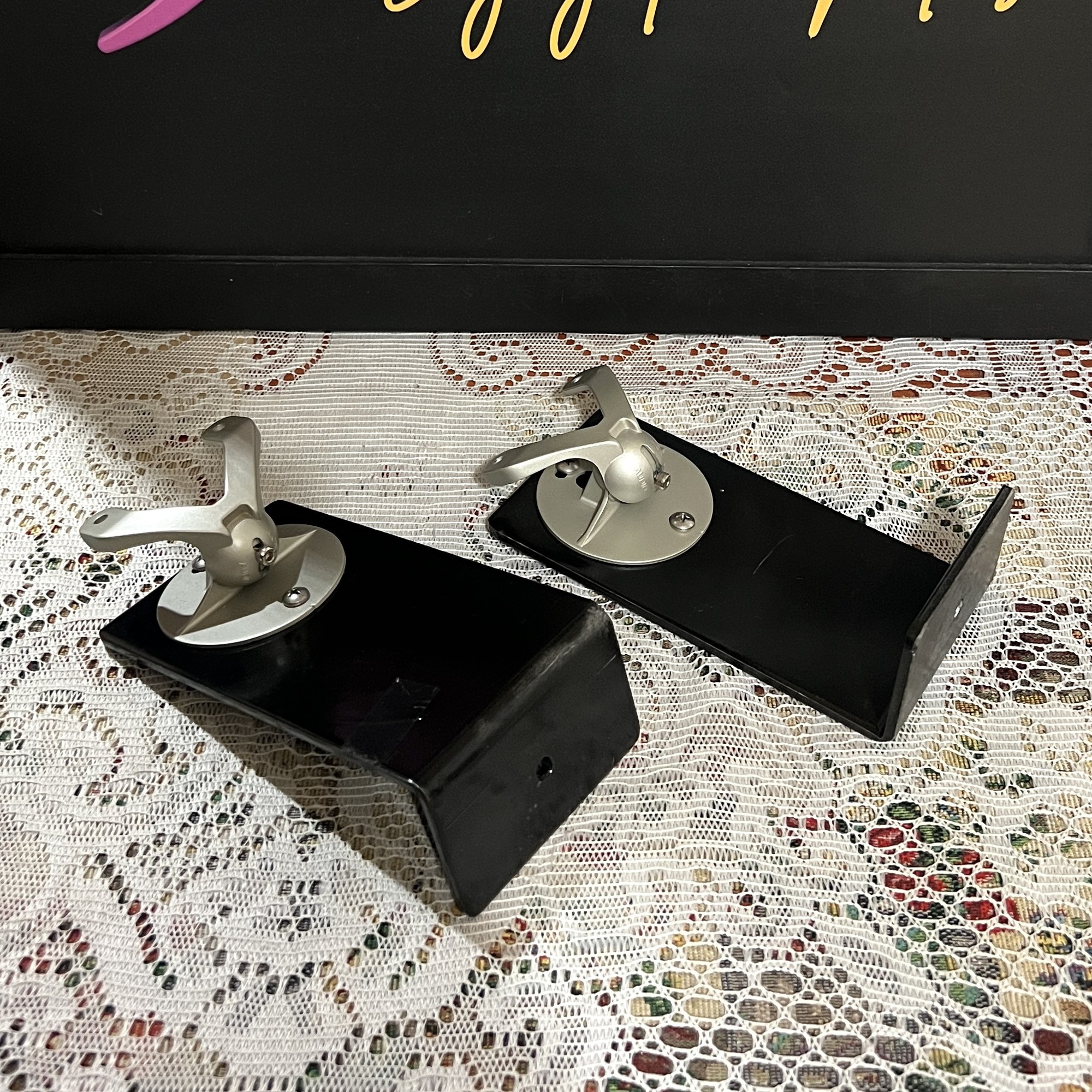 Monitor-Audio-Radius-90-Wall-Brackets-Pair-Front-Angle-Thumb Monitor Audio Radius 90 wall brackets, a pair of black L-shaped arms each topped with a silver swivel ball joint and speaker mounting plate
