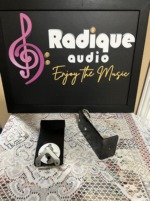 Pair of Monitor Audio Radius 90 wall brackets from the side, one silver swivel plate facing the camera and the black steel arm beside it