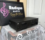 NAD 6130 cassette deck at an angle, slim black case with the cassette door at left and level controls at the right end