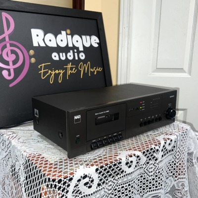 NAD 6130 cassette deck at an angle, slim black case with the cassette door at left and level controls at the right end
