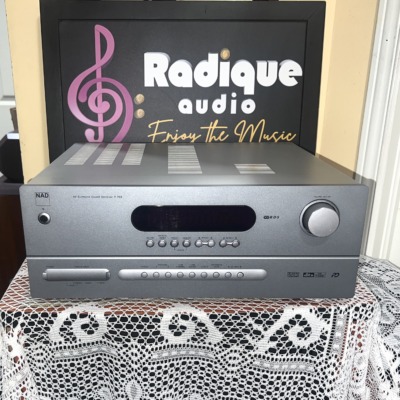 NAD T 753 AV surround sound receiver in silver, front panel with a wide black display window, large volume knob and a row of input buttons