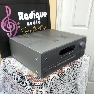 NAD T 753 receiver seen from the left front corner, showing its silver casing, vented top cover and display window