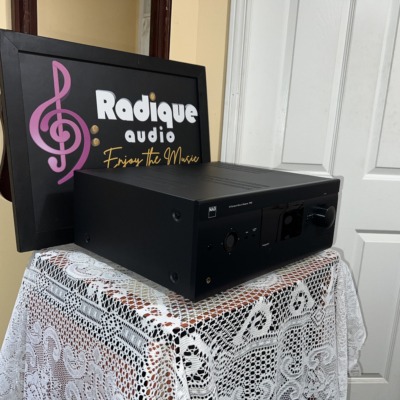 NAD T 757 receiver seen from a front angle on the lace-covered table by the Radique backdrop