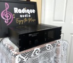 Nikko Alpha 230 power amplifier seen from the left at an angle, black chassis with rack-mount ears and a vented top cover