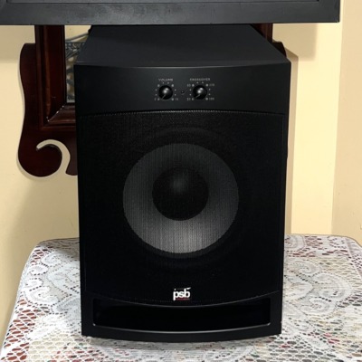 PSB Alpha SubZero i powered subwoofer in black with its metal grille fitted, front view