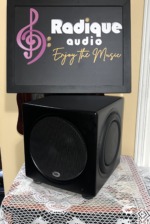PSB SubSeries HD10 subwoofer at a slight angle, satin black cabinet with the front grille and a passive radiator on the side panel