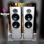 Paradigm 11se Mk II floorstanding speakers, grilles off, pale grey baffles with a dome tweeter above two black woofers in black cabinets