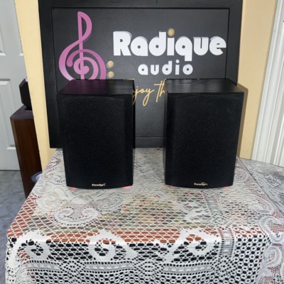 Pair of Paradigm Micro v.3 bookshelf speakers in black ash, black cloth grilles with the Paradigm badge at the bottom