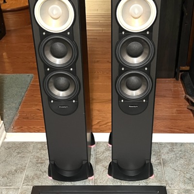 Pair of black Paradigm Monitor 7 v.6 tower speakers, grilles off, showing the tweeter, light-coloured midrange cone and twin black woofers
