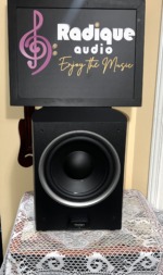 Paradigm PDR-10 v.4 powered subwoofer with grille off, showing the 10-inch black cone with its silver trim ring and the Paradigm badge below