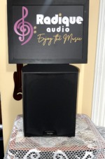 Paradigm PDR-10 v.4 subwoofer with its black grille fitted and the Paradigm badge centred at the base of the front
