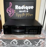 Pioneer PD-7700 compact disc player, front panel with disc tray and transport buttons, on lace in front of the Radique backdrop