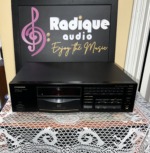 Pioneer PD-7700 compact disc player, front panel with disc tray and transport buttons, on lace in front of the Radique backdrop