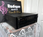 Pioneer VSX-9900S receiver from the left at an angle, black case with vented top, lit display and large volume knob on the right