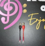 Pair of Radique Audio small spade adapters, red and black, clear-topped banana sockets above small spade forks