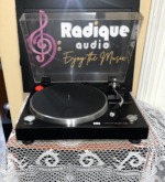 Sansui P-50 with the clear dust cover raised, showing the silver-rimmed platter, speed selector, straight tonearm and stop control