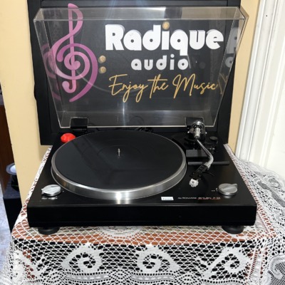 Sansui P-50 with the clear dust cover raised, showing the silver-rimmed platter, speed selector, straight tonearm and stop control