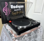 Sansui P-50 from the left at an angle with the clear cover raised, platter, tonearm and controls on the black plinth