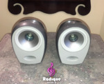 Pair of silver Tannoy Arena satellite speakers, grilles off, showing the light grey baffles and Dual Concentric drivers above the front ports