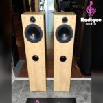 Tannoy Mercury F3 floorstanders in light Apple finish, grilles off — a 6.5 inch bass/mid driver above the front port on each cabinet.