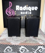 Tannoy Mercury FR Custom bookshelf speakers with their black cloth grilles fitted, Tannoy badges on the lower edge