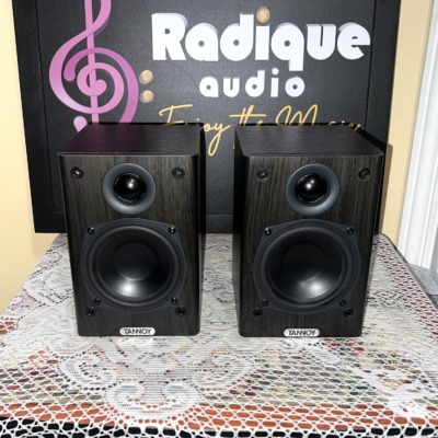 Tannoy Mercury FR Custom bookshelf speakers, dark wood-grain cabinets with grilles off showing the tweeter and black woofer