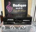 Technics RS-TR210 double cassette deck in black, deck 1 and deck 2 wells with a blue level display, balance and record level knobs