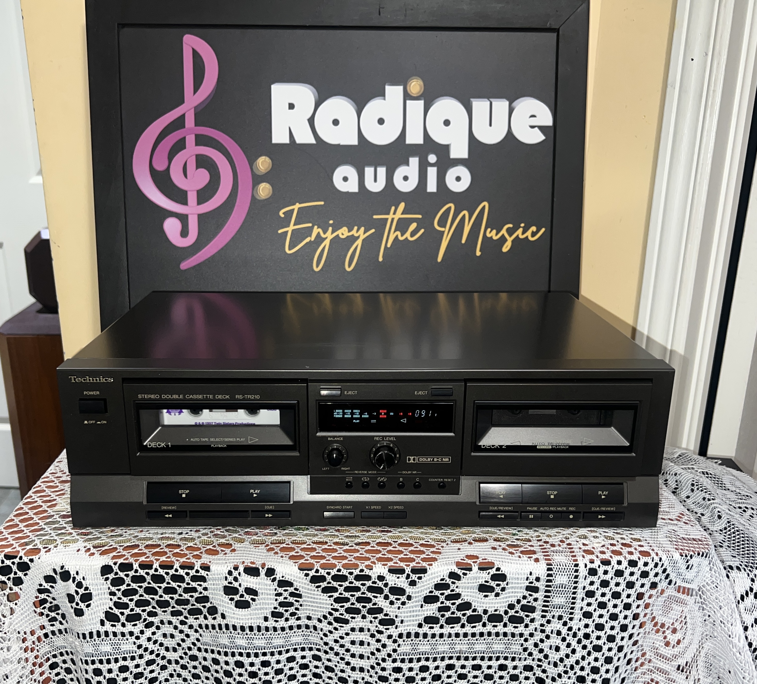 Technics-RS-TR210-Stereo-Double-Cassette-Deck-Front Technics RS-TR210 double cassette deck in black, deck 1 and deck 2 wells with a blue level display, balance and record level knobs