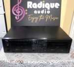 Yamaha KX-W232 double cassette deck in black, front panel with Deck A record/playback and Deck B playback doors, tape counter and peak level meters