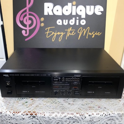 Yamaha KX-W232 double cassette deck in black, front panel with Deck A record/playback and Deck B playback doors, tape counter and peak level meters