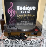 Rear of the Yamaha YP-211 turntable, wood-grain plinth with the Yamaha NS Series model plate, power cord and RCA phono cables