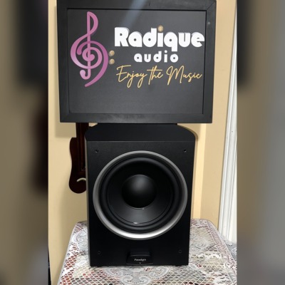 Paradigm PDR-10 v.4 powered subwoofer with grille off, showing the 10-inch black cone with its silver trim ring and the Paradigm badge below