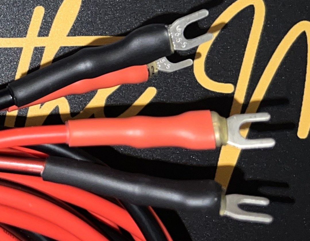 Small spade speaker cable terminations by Radique Audio, crimped forks under red and black colour-coded heat-shrink